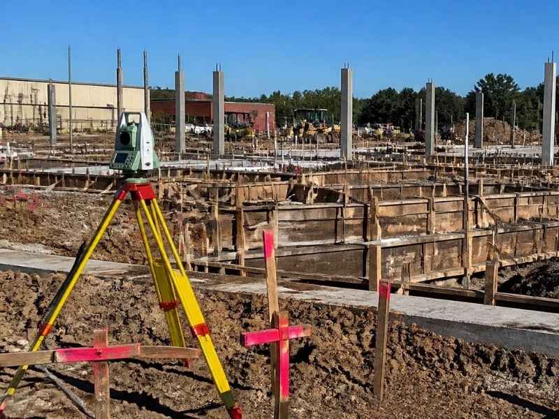 Construction surveyors in Columbus GA using survey equipment and layout stakes to maintain accurate building placement on a jobsite.